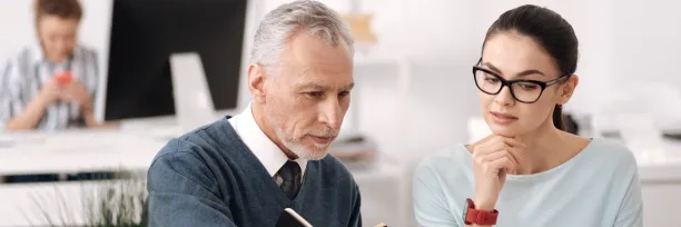 Two professionals reviewing work on a computer